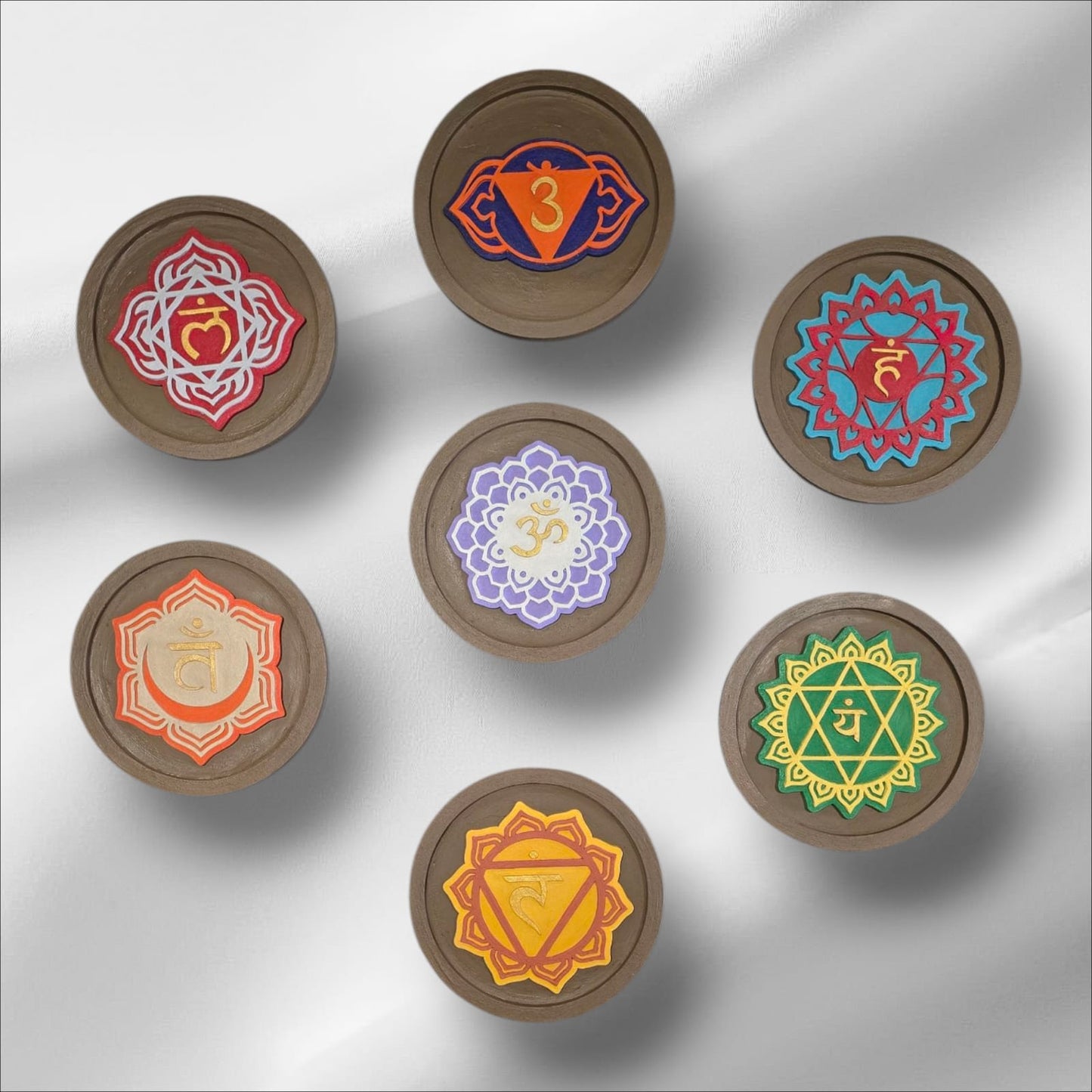 Set of seven wooden discs with colorful mandala designs on a white background