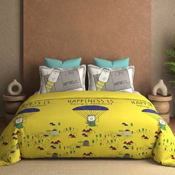 Yellow bedding set with 'happiness is' design on a bed with matching pillows.