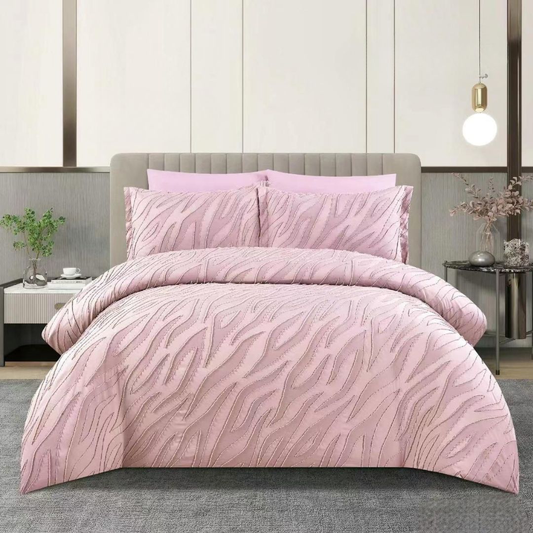 Pink zebra print comforter set on a bed in a bedroom setting.