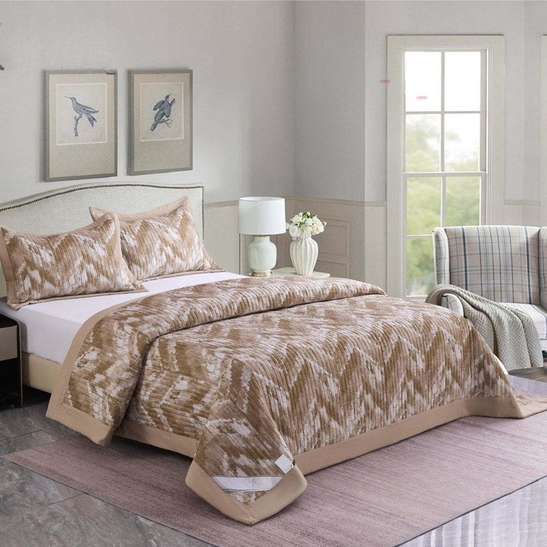 Bedroom with a bed covered in a beige patterned comforter, lamp, and decor items.