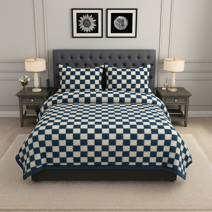 Bedroom with a bed covered in a blue and white checkered comforter, two nightstands with lamps, and framed artwork on the wall.