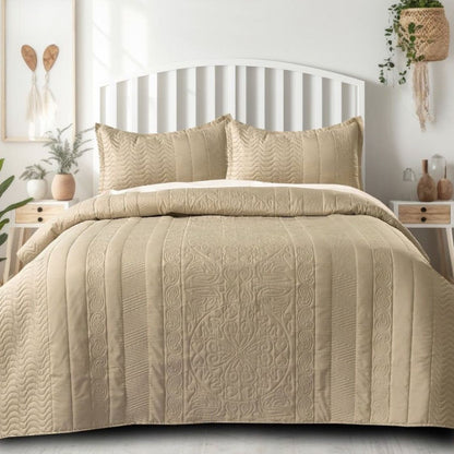 Beige quilt set on a bed in a bedroom setting with decor elements.