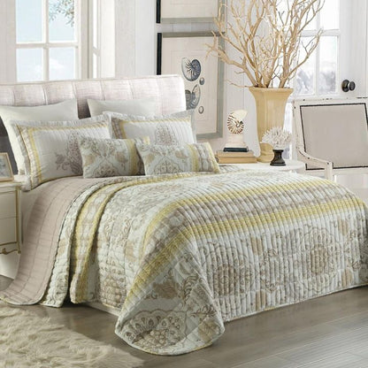 Neatly made bed with patterned bedding in a bright bedroom.