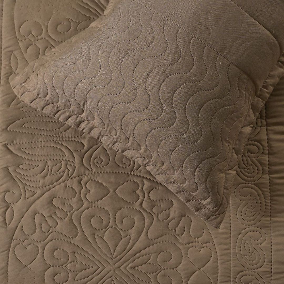 Close-up of a textured brown quilt with intricate patterns