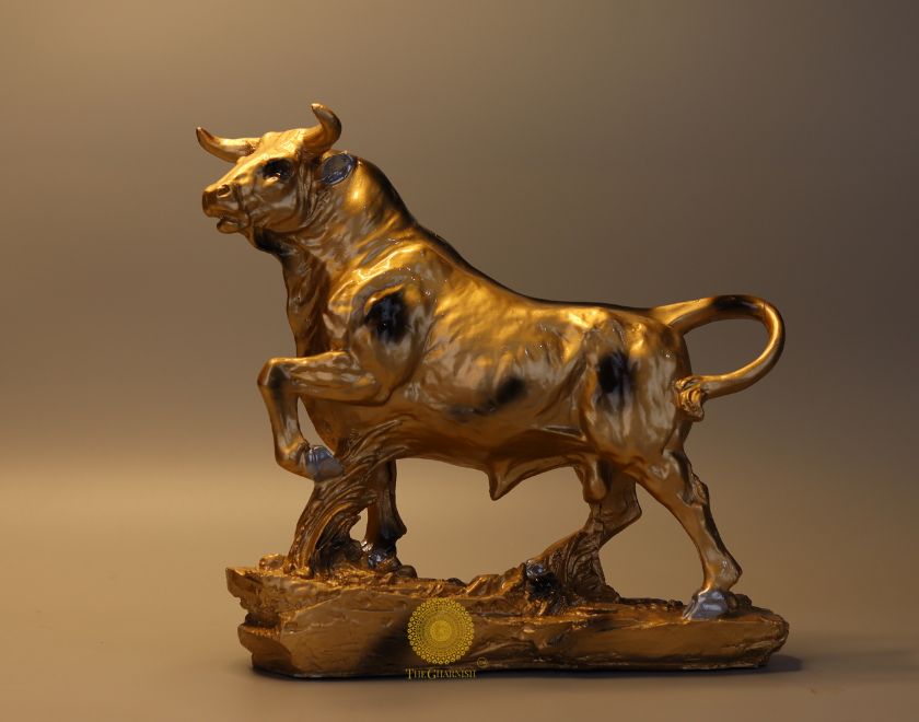 Large brown Charging Bull statue by The Gharnish, animal figurine with detailed muscular features and dynamic stance.
