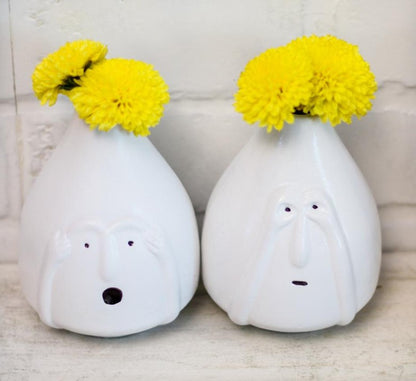 Set of two ceramic vases with facial feature designs by The Gharnish, showcasing artistic facial expressions in a decorative ceramic style.
