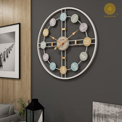 Metallic wall clock with Roman numerals, 24-inch diameter, by The Gharnish. Modern design with a sleek finish.