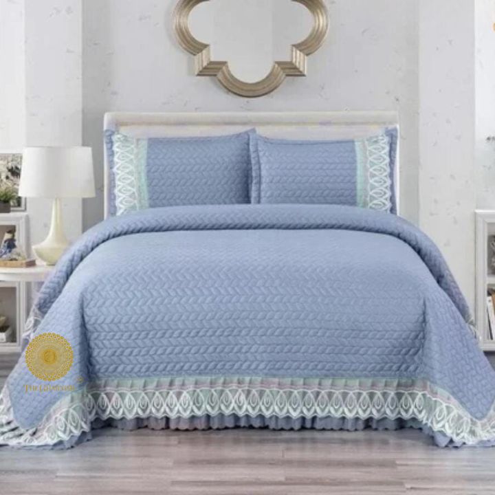 Astria Premium quilted and laced bedcover from The Gharnish featuring intricate quilting and elegant lace details on a bed.