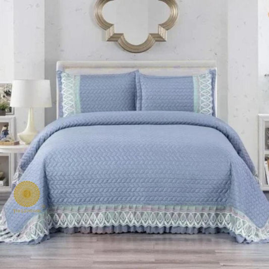 Astria Premium quilted and laced bedcover from The Gharnish featuring intricate quilting and elegant lace details on a bed.