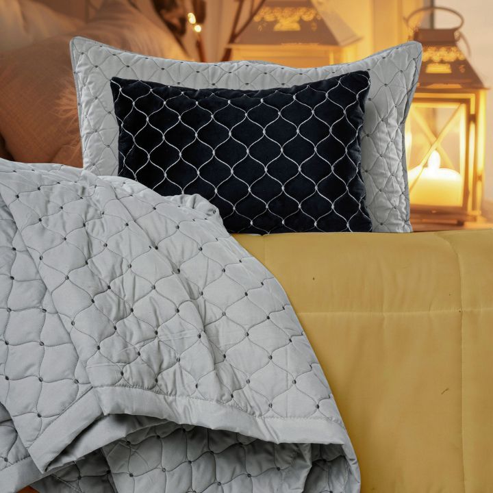 Luxury quilted bedding set by The Gharnish with bedcover, pillow, and cushion covers, featuring elegant stitching and plush fabric.