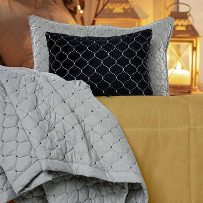 Luxury quilted bedding set by The Gharnish with bedcover, pillow, and cushion covers, featuring elegant stitching and plush fabric.