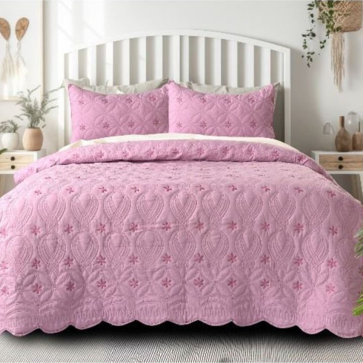 The Gharnish Swrill quilted bedding set of 3 with unique geometric design in neutral tones on a bed.