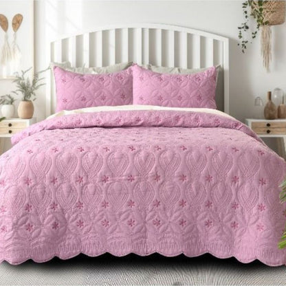 The Gharnish Swrill quilted bedding set of 3 with unique geometric design in neutral tones on a bed.