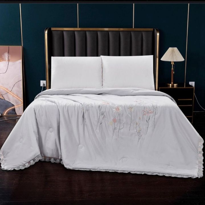 Luxury solid comforter with intricate embroidery from The Gharnish's summer collection, showcasing elegant design and plush fabric.