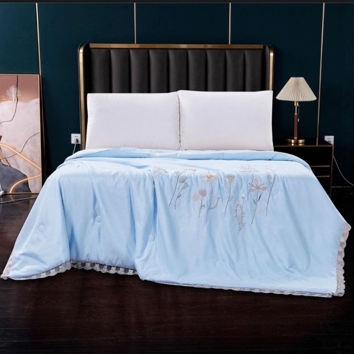 Elegant luxury solid comforter with embroidery from The Gharnish summer collection, showcasing intricate stitching and plush fabric.