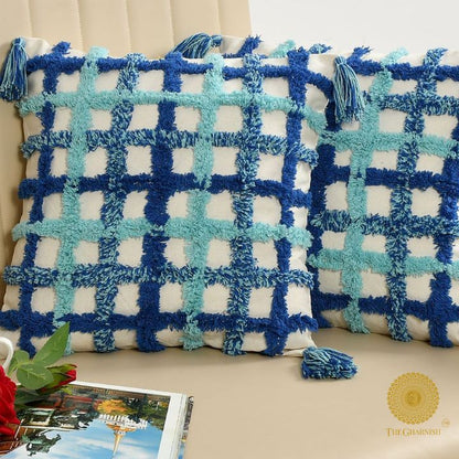 Set of two soft white and blue tassel cushions by The Gharnish, 16x16 inches, with decorative tassel details.