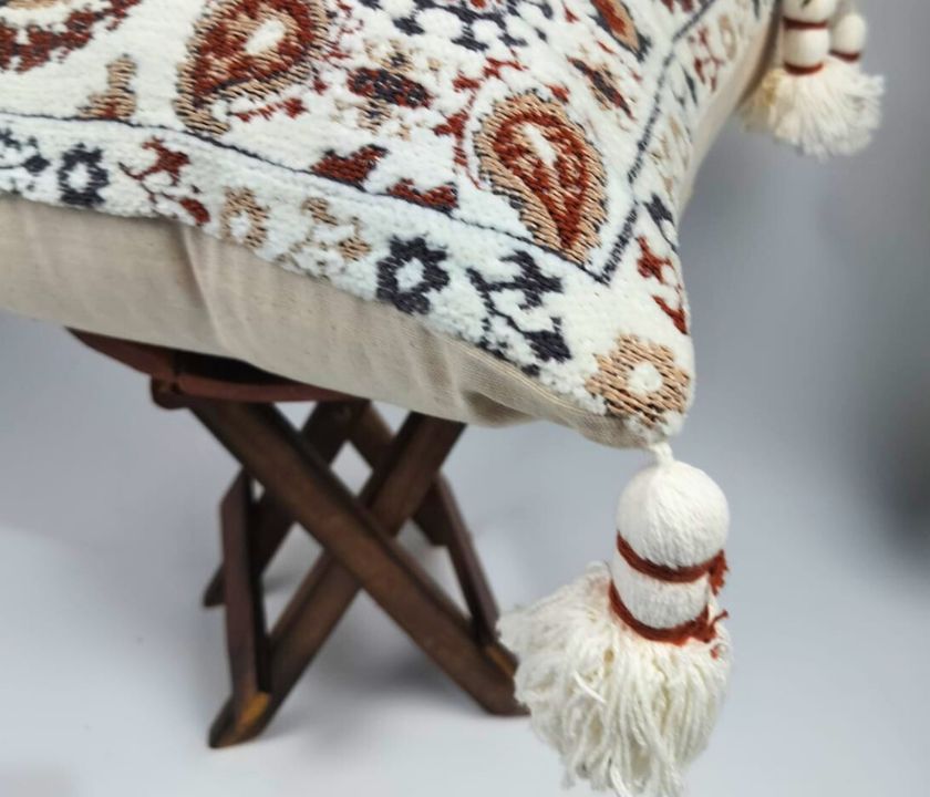 Pure cotton Hanblocked cushion cover with tassels by The Gharnish, featuring traditional handwoven patterns and decorative tassel accents.