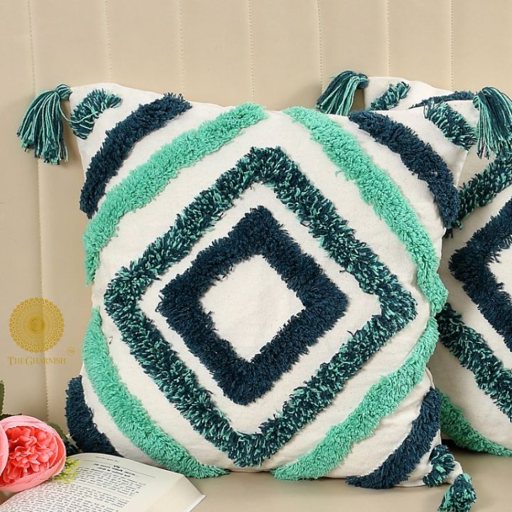 Set of two handcrafted white and blue tassel cushions by The Gharnish, featuring decorative tassels and soft fabric.