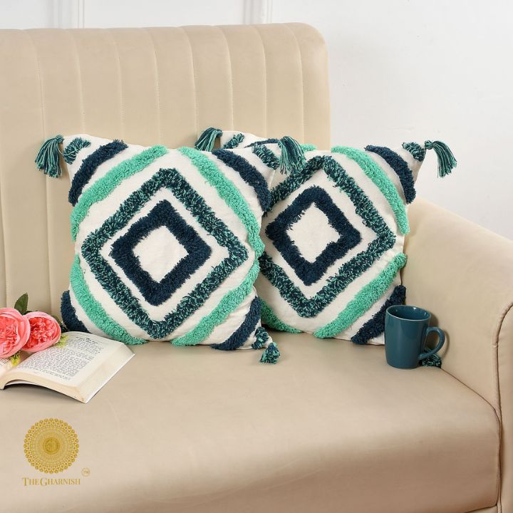 Set of two handcrafted white and blue tassels cushions by The Gharnish, featuring decorative tassel accents and soft fabric.