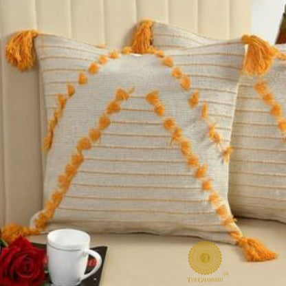 Set of two yellow tassel cushion covers by The Gharnish, handcrafted with decorative tassels for a stylish home decor touch.