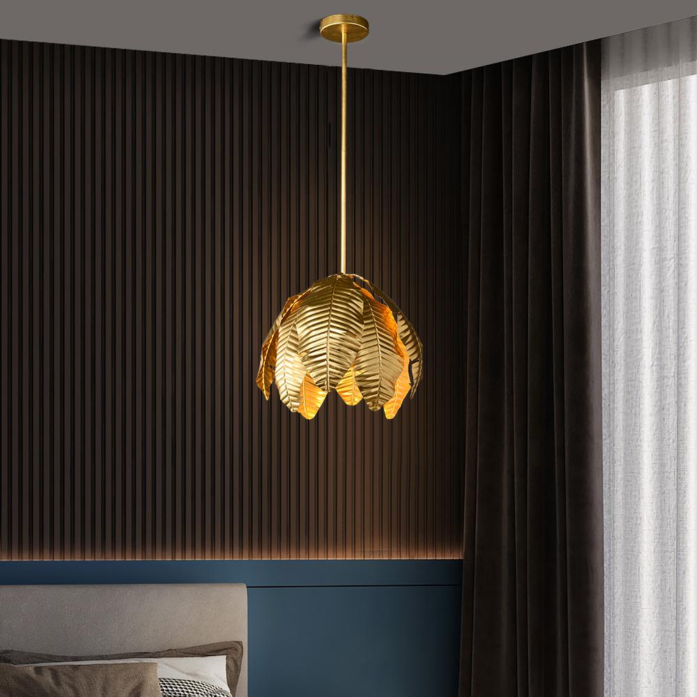 Gold palm leaf hanging pendant light by The Gharnish, stylish floor lamp with intricate leaf design and warm gold finish.