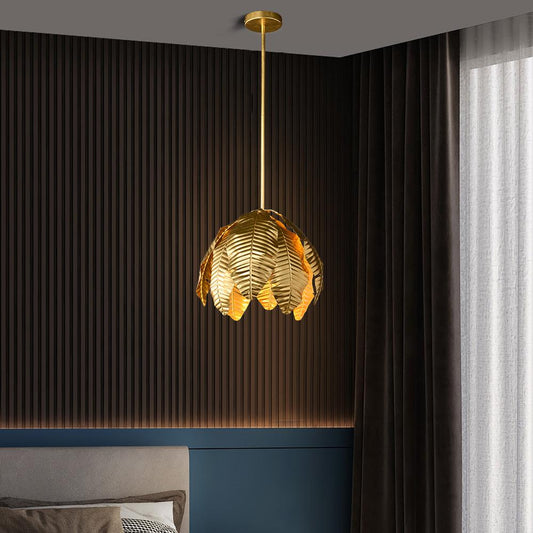 Gold palm leaf hanging pendant light by The Gharnish, stylish floor lamp with intricate leaf design and warm gold finish.