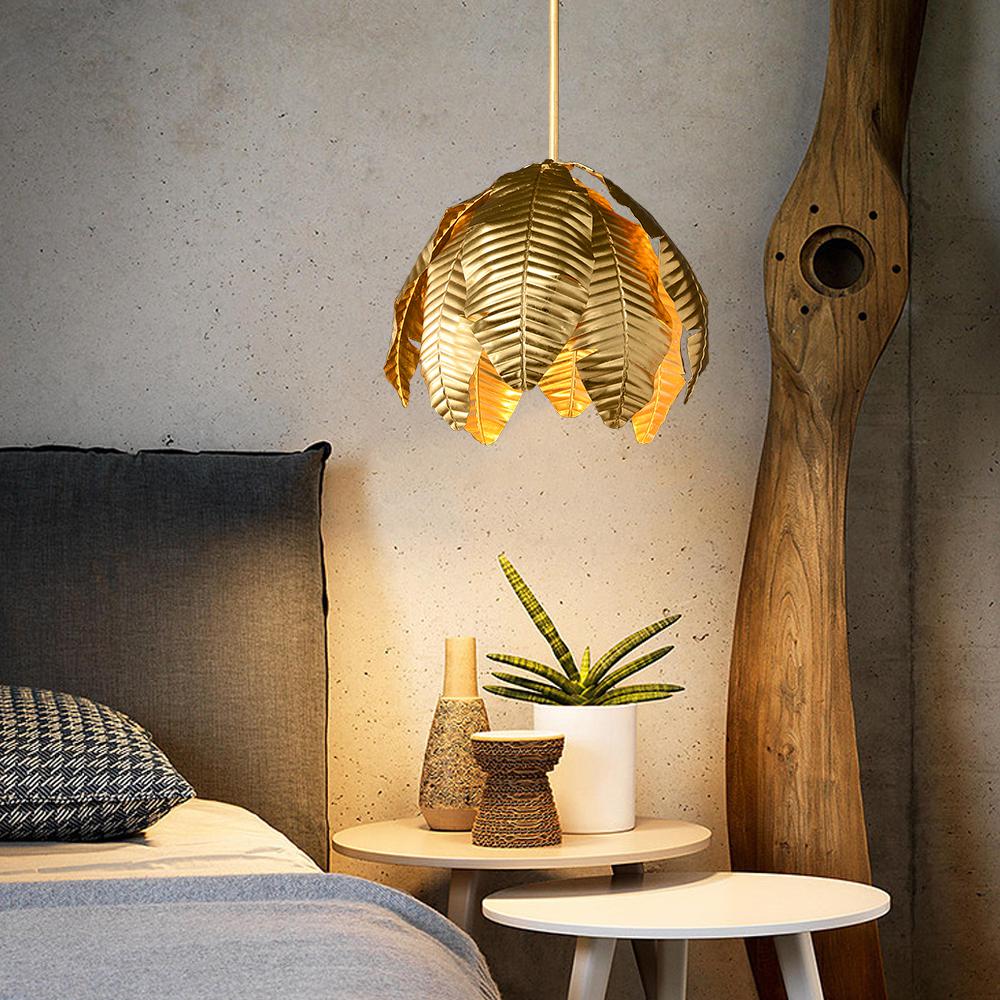 Gold palm leaf hanging pendant light from The Gharnish, stylish floor lamp with a tropical leaf design and warm gold finish.