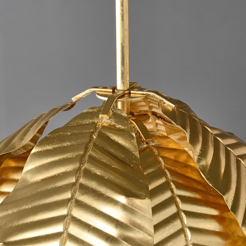 Gold palm leaf hanging pendant light from The Gharnish, stylish floor lamp with a tropical leaf design and warm gold finish.