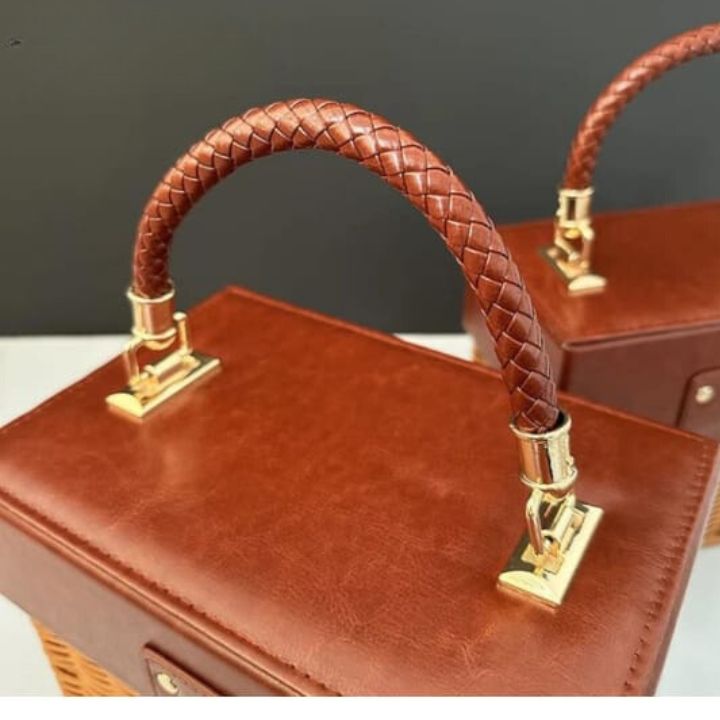 Small souvenir leather and rattan storage basket by The Gharnish, with a woven design and compact storage solution.