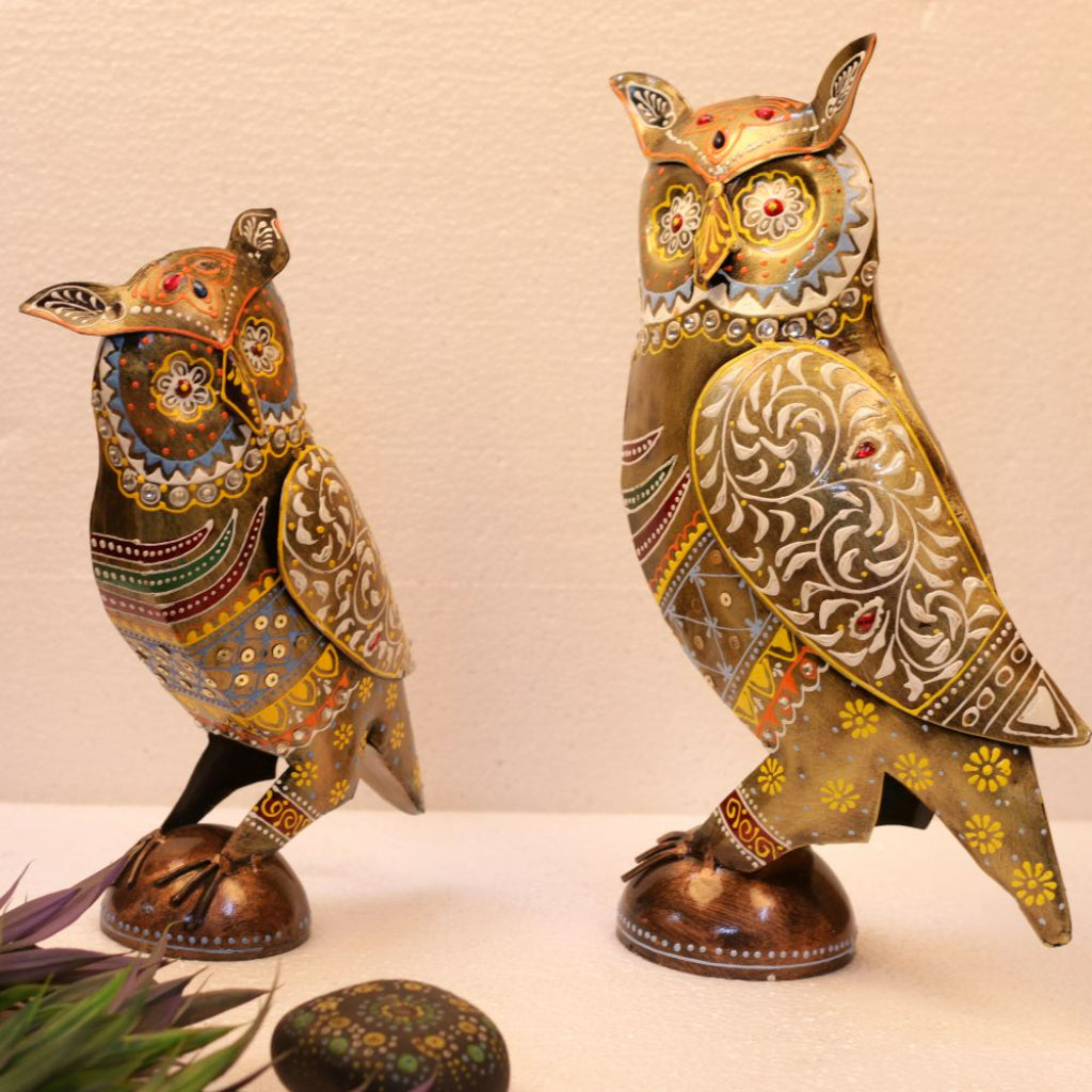 Set of two multicolor painted metal owl table top decor pieces by The Gharnish, featuring vibrant, detailed owl designs.