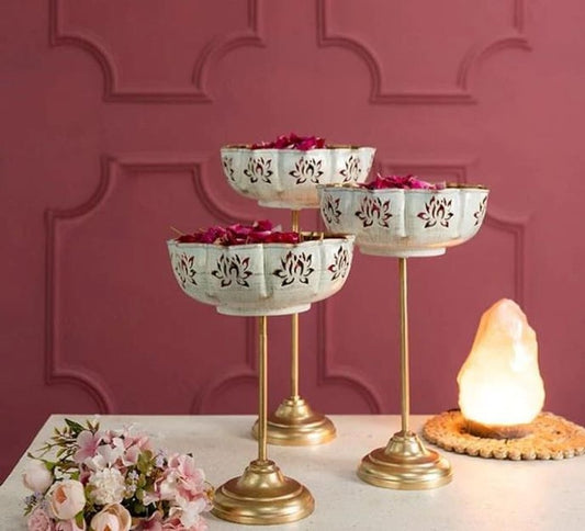 Set of three gold Lotus Jali Urli bowls with stands by The Gharnish, featuring intricate lotus design and elegant craftsmanship.
