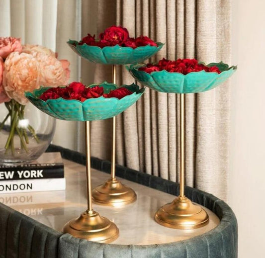 Set of three gold Lotus Urli bowls with stands by The Gharnish, elegant traditional decorative pieces.