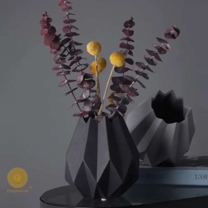 Small black ceramic vase shaped like a lotus flower by The Gharnish, showcasing intricate petal details and a glossy finish.