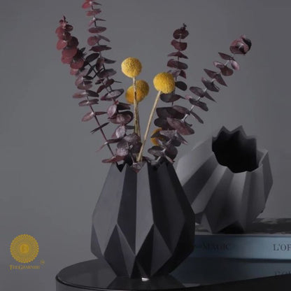 Small black ceramic vase shaped like a lotus flower by The Gharnish, showcasing intricate petal details and a glossy finish.