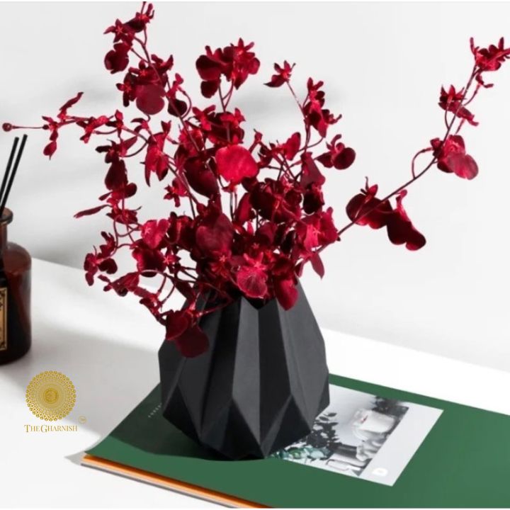 Small black ceramic vase in a lotus flower shape by The Gharnish, featuring intricate petal details and a glossy finish.