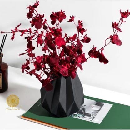 Small black ceramic vase in a lotus flower shape by The Gharnish, featuring intricate petal details and a glossy finish.