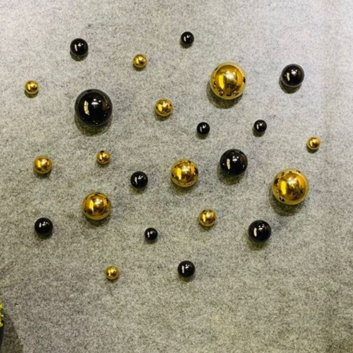 Three PVD coated decorative metallic balls arranged as modern wall art for contemporary home décor, showcasing shiny, reflective surfaces.