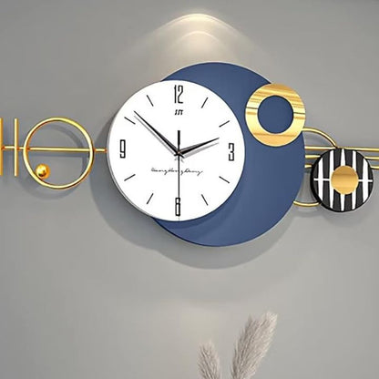 Arial Metallic Wall Clock by The Gharnish, 48x20 inches, showcasing a sleek, modern design with a metallic finish and bold numerals.
