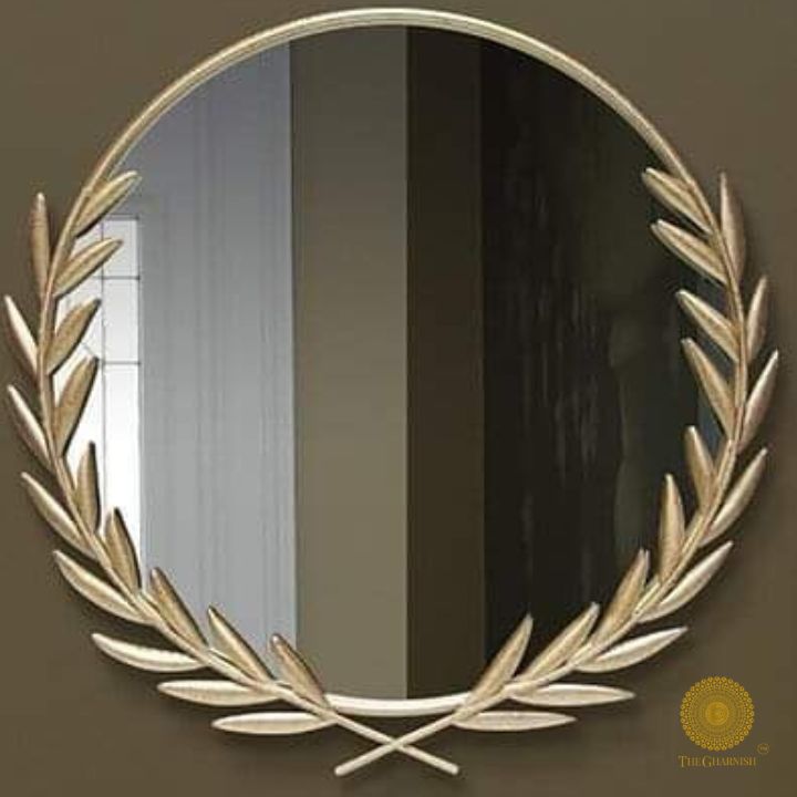Metallic palm leaf wall mirror with a 24-inch round reflective surface and decorative gold frame by The Gharnish.
