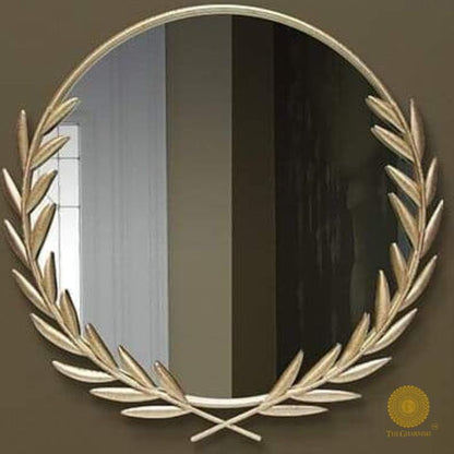 Metallic palm leaf wall mirror with a 24-inch round reflective surface and decorative gold frame by The Gharnish.
