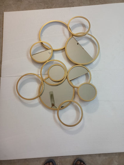 The Gharnish Ring of Rings wall mirror with a 36x26 inch round design featuring multiple ring accents.
