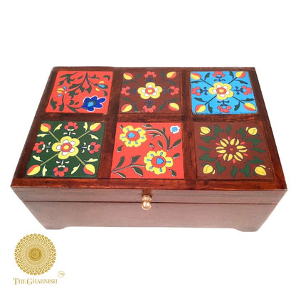 Colorful wooden jewelry box by The Gharnish, featuring multiple compartments for storing jewelry and accessories.