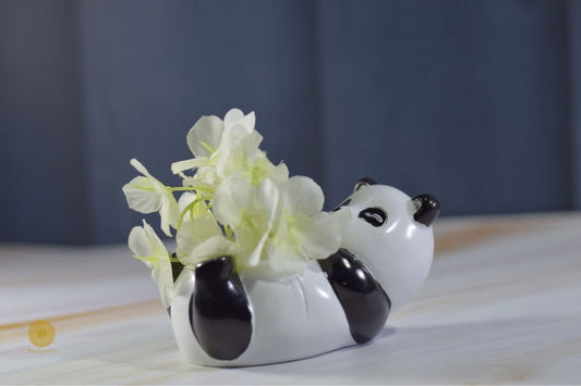 Miniature panda artwork by TheGharnish displayed in a small decorative pot, showcasing detailed craftsmanship and artistic design.
