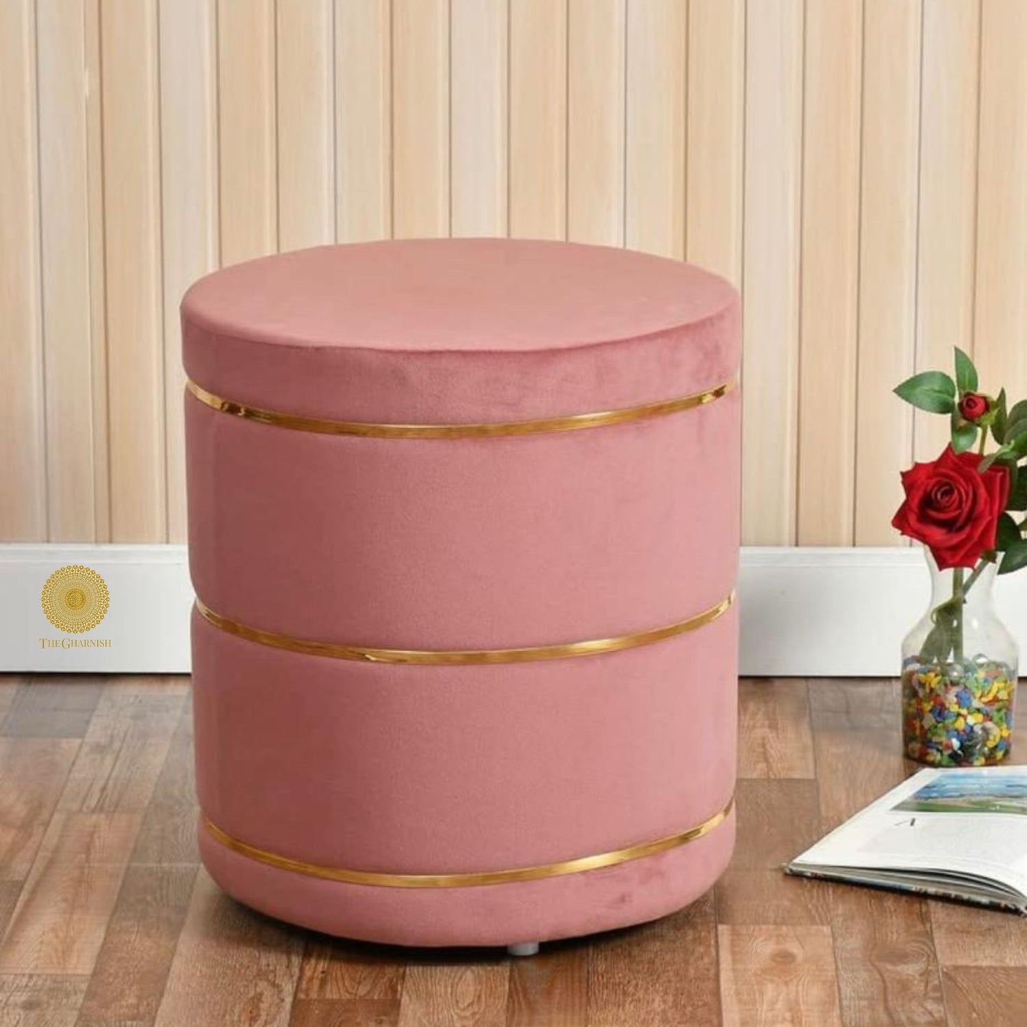 Pink fabric ottoman stool by The Gharnish, soft cushioned pouffe with a round shape and plush upholstery.