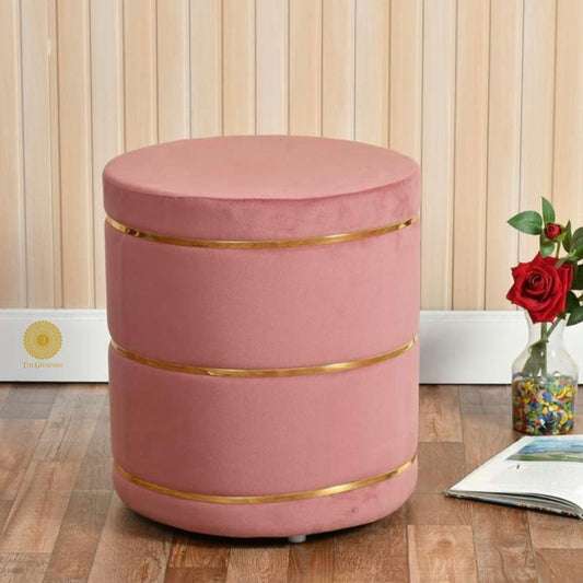 Pink fabric ottoman stool by The Gharnish, soft cushioned pouffe with a round shape and plush upholstery.